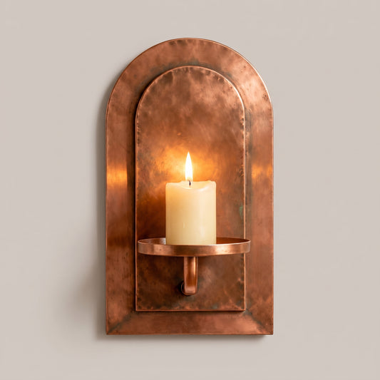 Marrakech Arch handcrafted aged red copper wall candle sconce with a lit pillar candle by Sahara Collection.