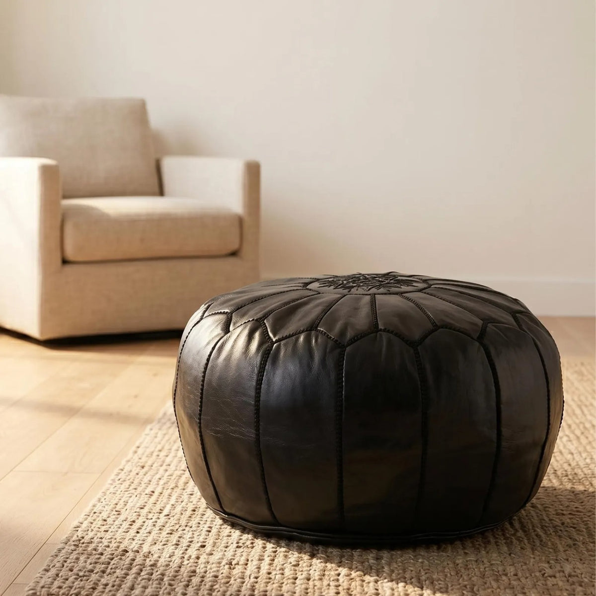 Black Moroccan leather pouf styled in a warm contemporary living room