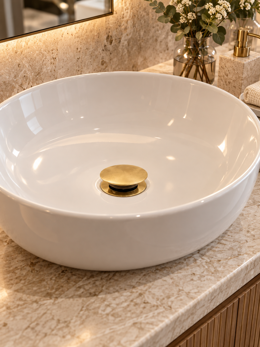 Unlacquered brass push-up drain installed in a luxury bathroom basin
