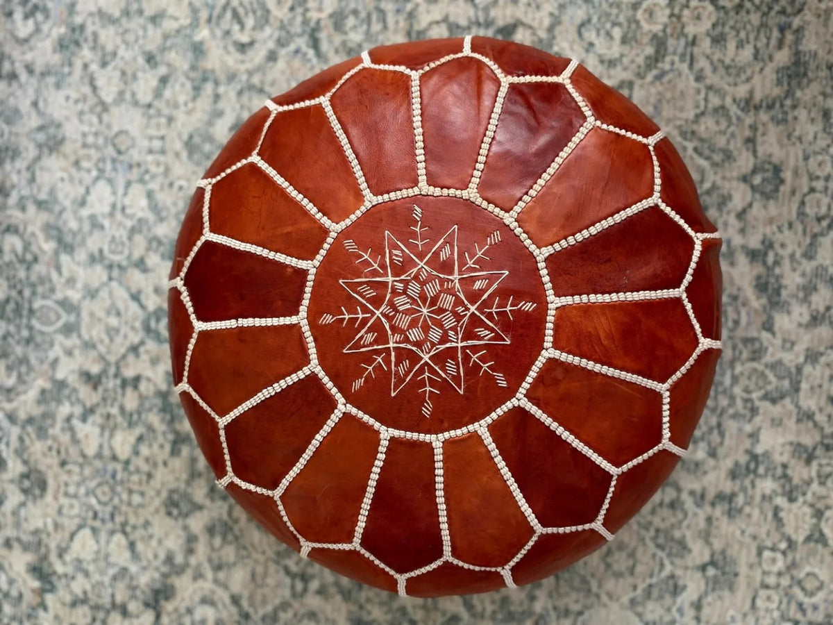 Full top view showing the hand-stitched pattern of a cognac Moroccan leather pouf
