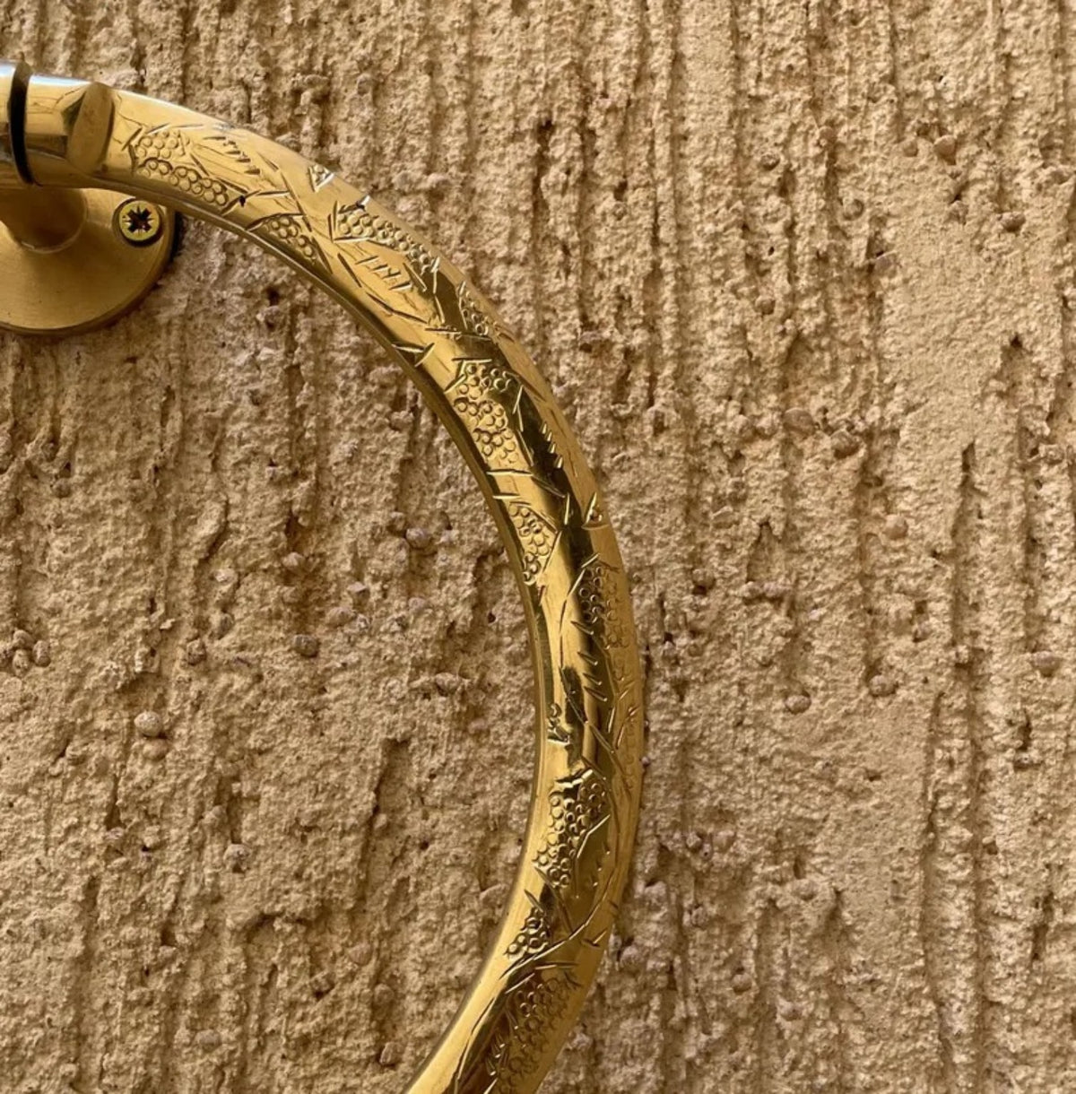 Close-up of hand engraving on solid brass towel ring
