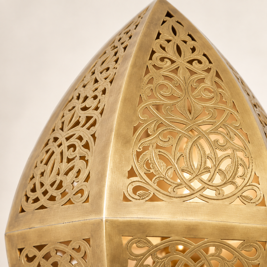Close-up of pierced floral arabesque craftsmanship on the brass wall sconce