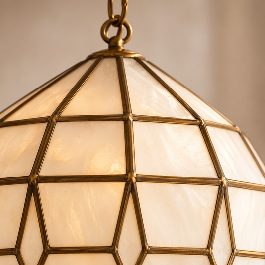 Close-up of handcrafted brass framework and milk glass