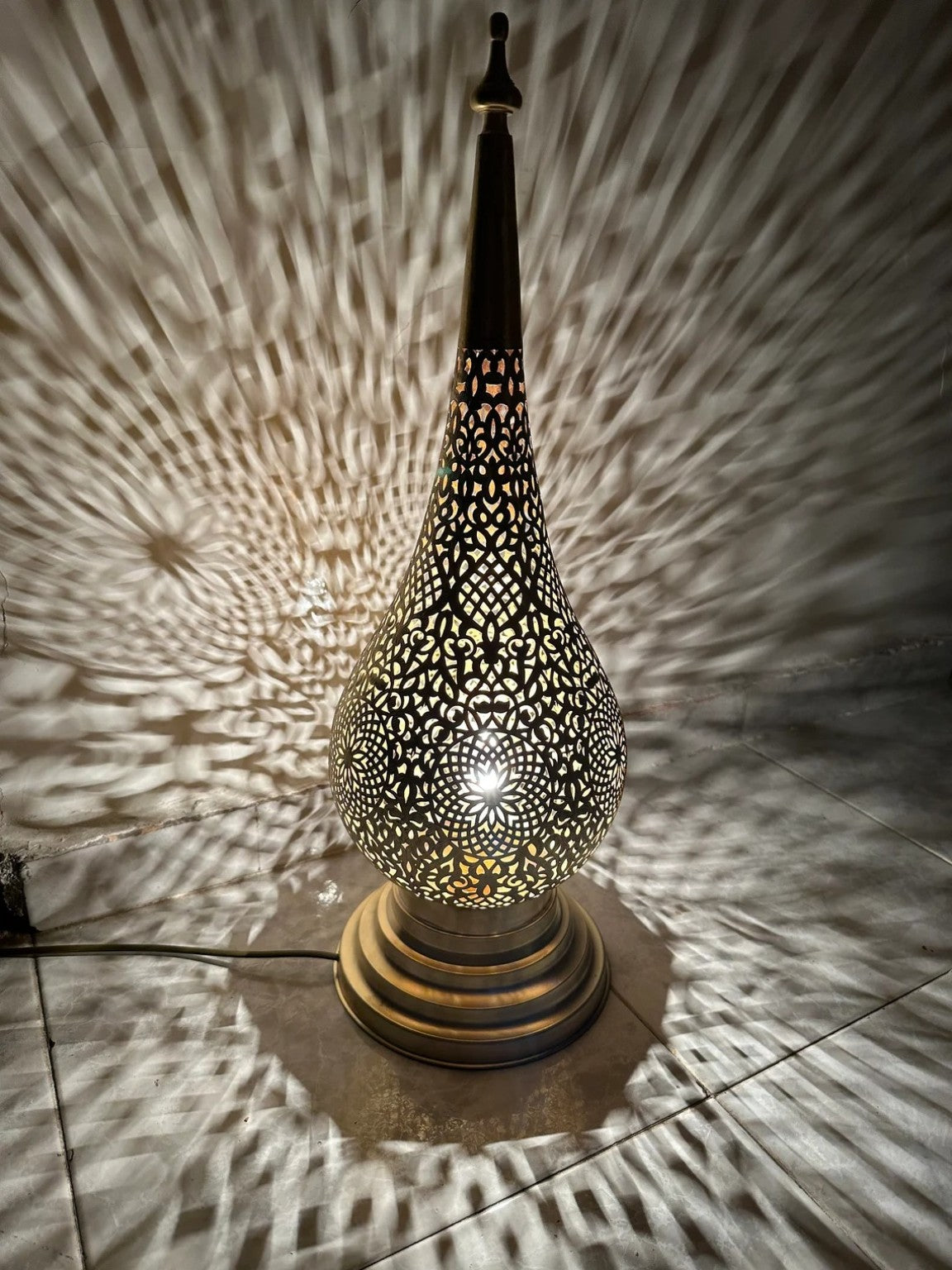 Moroccan teardrop lamp casting patterned shadows