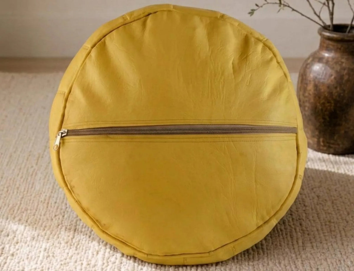 Concealed zip on the underside of a mustard yellow Moroccan leather pouf cover
