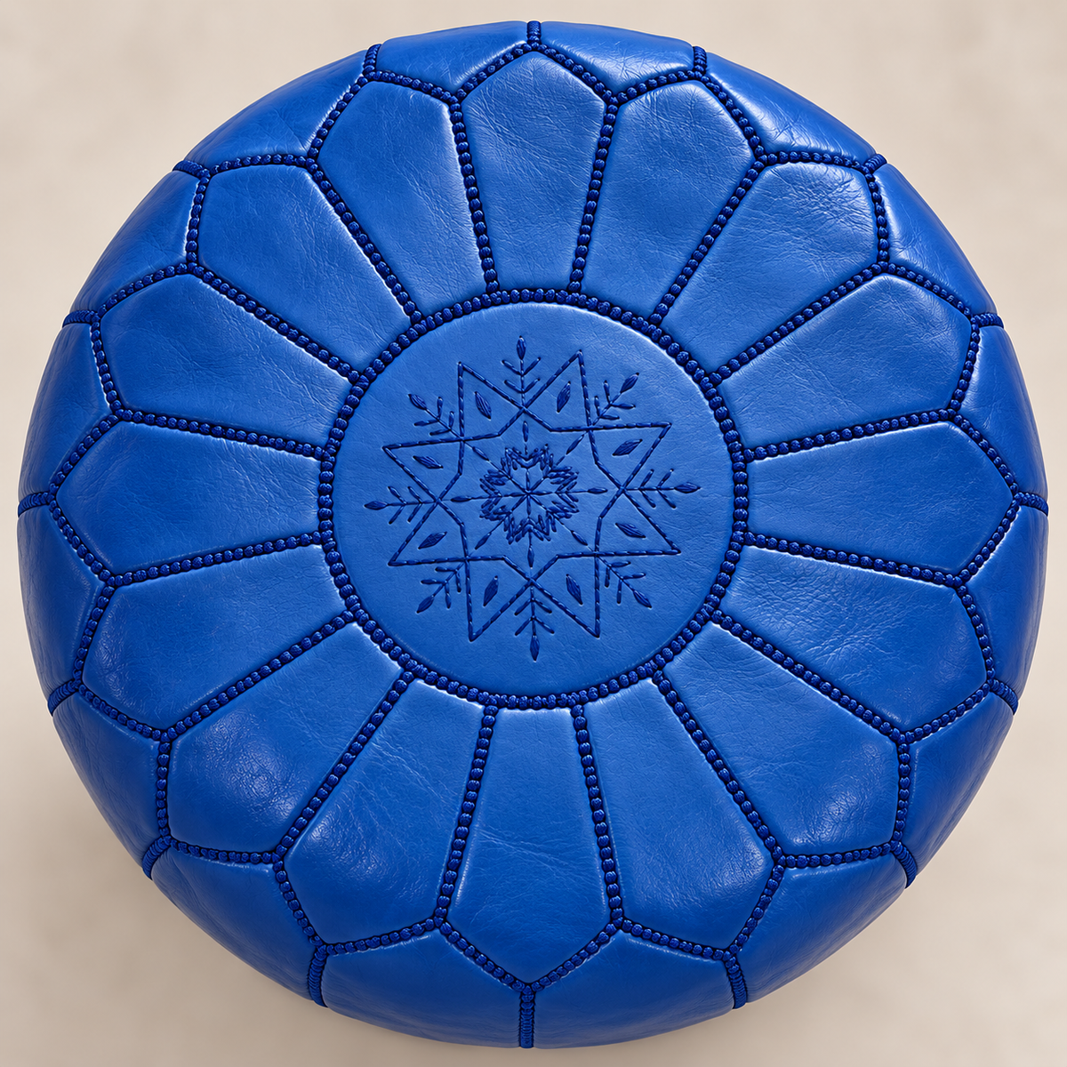 Close-up of the embroidery and hand stitching on a royal blue Moroccan pouf