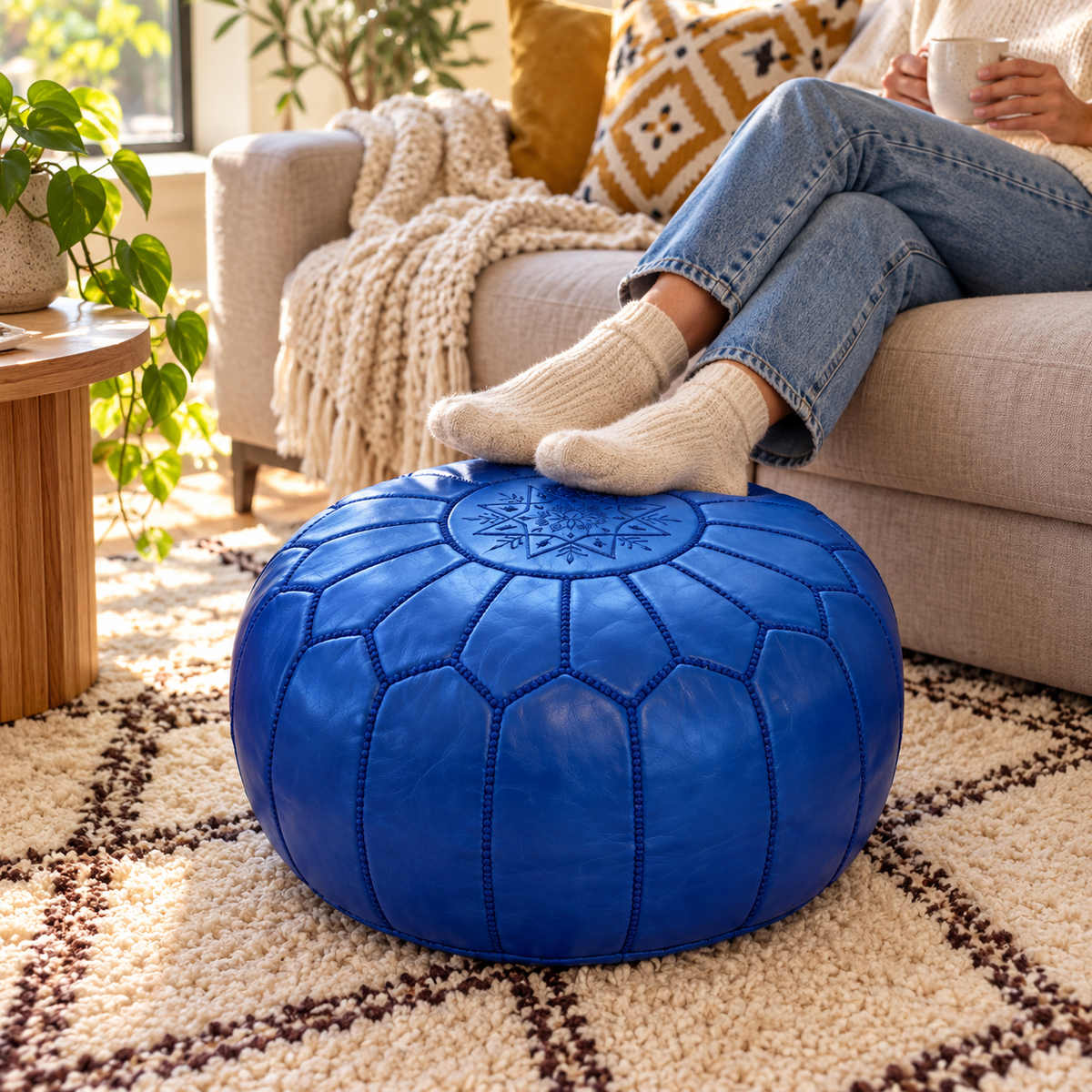 Person resting their feet on a royal blue Moroccan pouf