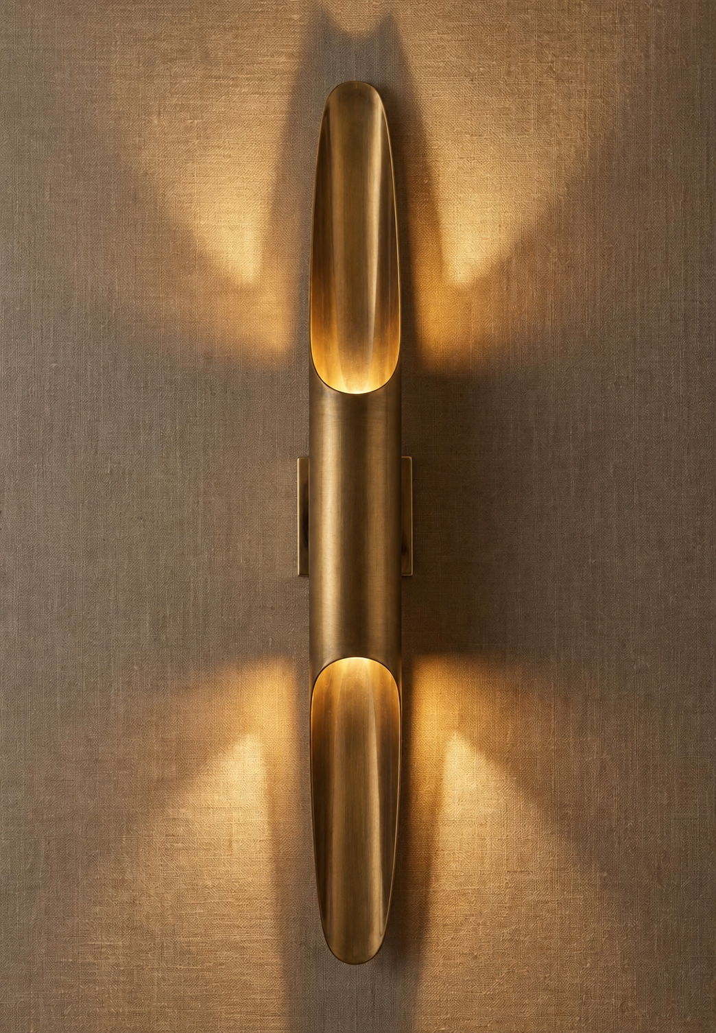 Sculptural brass tube wall sconce in antique patina finish