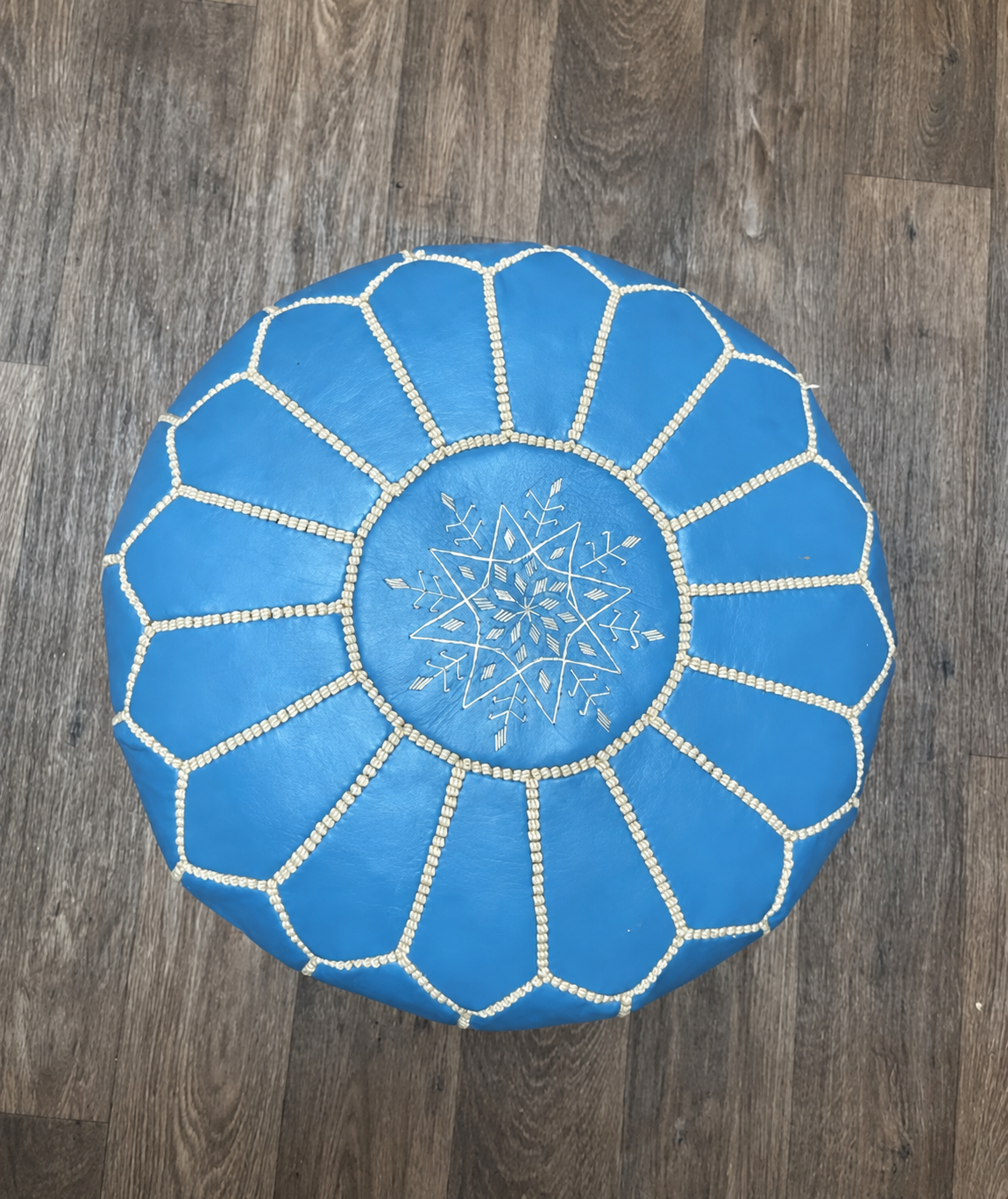Top view of sky blue Moroccan leather pouf with white embroidery