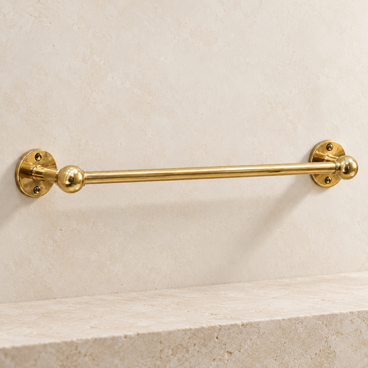 Handcrafted unlacquered brass towel bar with round wall plates and ball details