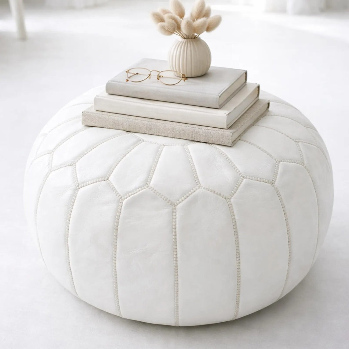 White handcrafted Moroccan leather pouf styled as an ottoman table